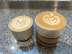 Left cup is a small oat flat white and right cup is a large soy flat white