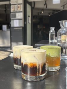Two mont blancs and one drink with a green foamy top and yellow-tea coloured drink underneath